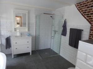 La salle de bains est pourvue d'une douche et d'un lavabo. dans l'établissement Ferienwohnung Elise im Gulfhof am Kanal, à Großefehn 