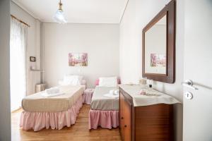 een slaapkamer met 2 bedden en een spiegel bij Family apartment at Kalithea 2 bedrooms 4 pers in Athene