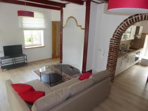 a living room with a couch and a glass table at Ferienwohnung Elise im Gulfhof am Kanal in Großefehn 