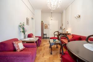 een woonkamer met rode banken en een tafel bij Family apartment at Kalithea 2 bedrooms 4 pers in Athene