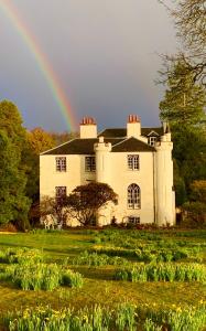 a rainbow in front of a large house with at Linnhe in Appin