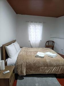 a bedroom with a bed and a table and a window at Cobal 's HOUSE in Viseu