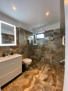 a bathroom with a toilet and a sink and a shower at ANA Apartments Sinaia in Sinaia