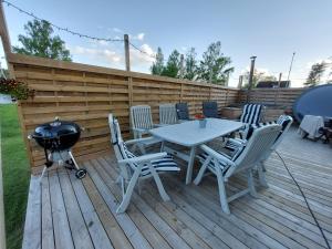 una mesa de picnic y sillas en una terraza con parrilla en Rumskulla Guesthouse 3 Room Apartment 8 beds, en Vimmerby