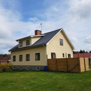 ein großes weißes Haus mit einem Holzzaun in der Unterkunft Rumskulla guesthouse in Vimmerby