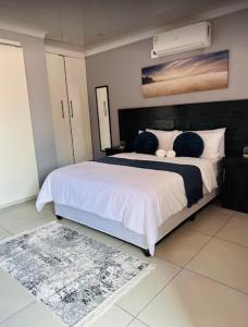 a bedroom with a large bed with a white comforter at Sekos Guest House & Shisanyama in St Lucia