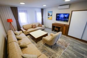 a living room with a couch and a tv at Old House Apartment in Pristina