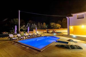 een zwembad in een tuin 's nachts bij Villa in Omiš inland/4 stars+heated pool in Nova Sela