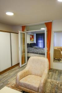 a living room with a chair and a bed at Old House Apartment in Pristina