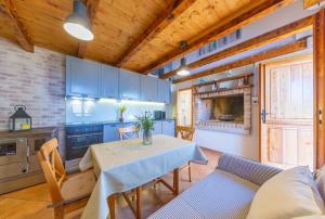 a kitchen with a table and some blue cabinets at Adorable Cottage in Oključna