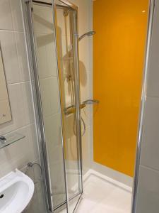 une douche avec une porte en verre à côté d'un lavabo dans l'établissement For Students Only Ensuite Bedrooms with Shared Kitchen at Cathedral Point in Winchester, à Winchester