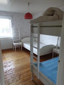 a bedroom with two bunk beds and a window at Större gäststuga 