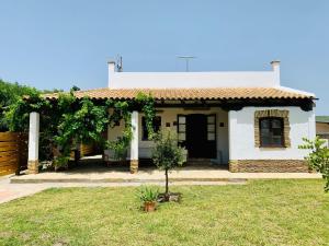 una pequeña casa blanca con un árbol en el patio en Casa Manuela, en El Palmar