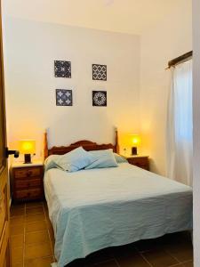 sypialnia z łóżkiem i dwoma lampami na dwóch stołach w obiekcie Casa Manuela w mieście El Palmar