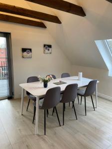 a dining room with a white table and chairs at Hilmor's Lejligheder in Viborg