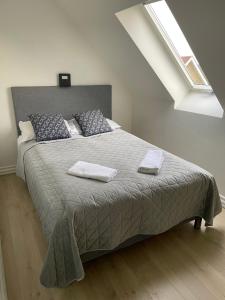 a bedroom with a large bed with two towels on it at Hilmor's Lejligheder in Viborg