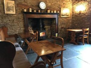 a living room with tables and a fireplace with a clock at Castle Inn in Knighton