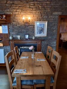 a wooden table in a restaurant with a stone wall at Castle Inn in Knighton