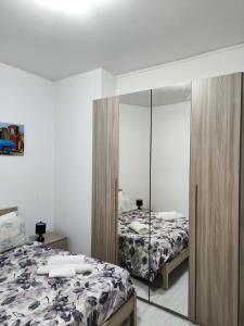 a bedroom with two beds and a mirror at Appartamento C&Y Torelli in Novara