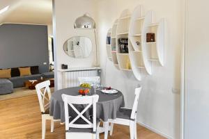 a dining room with a table and white chairs at Sant’Andrea Penthouse by Montenapoleone Living in Milan