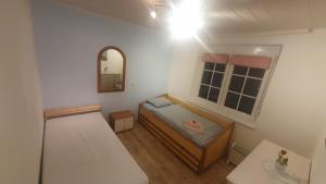 ein kleines Zimmer mit einem Bett und einem Spiegel in der Unterkunft AUSZEIT am Steinbichl in Feistritz am Wechsel