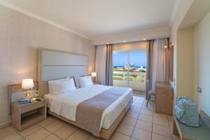 a hotel room with a bed and a large window at Athineon Hotel in Rhodes Town
