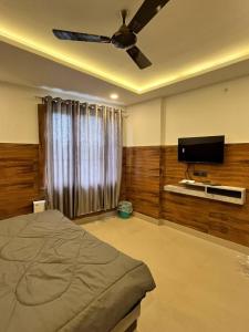 a bedroom with a bed and a flat screen tv at Hotel Shanti Residency in Katra