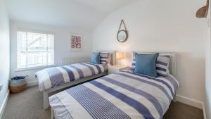 a bedroom with two beds and a window at Sea Breeze Apartment in Walton-on-the-Naze