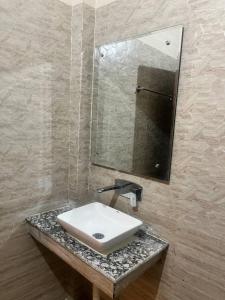 bagno con lavandino bianco e specchio di Hotel Shanti Residency a Katra