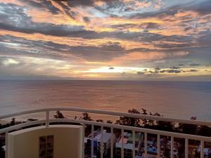 a view of the ocean from a balcony at sunset at Waterfront Karon Beach by PHR in Karon Beach
