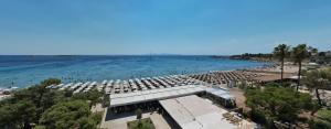 an aerial view of a beach with chairs and the ocean at Parthenis Riviera Hotel in Athens