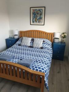 a bedroom with a bed with a blue and white comforter at Nelson Heights - Perfect seaside retreat, Cromer in Cromer