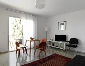 a living room with a table and chairs and a television at Casa Malaga in El Palo