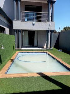 a swimming pool in the yard of a house at R&R GUEST HOUSE in Lenyenye