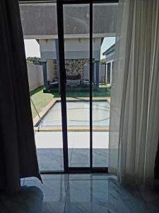 una finestra aperta con vista sulla piscina di R&R GUEST HOUSE a Lenyenye