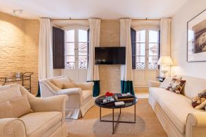een woonkamer met een bank en een tafel bij Real Casa de la Moneda Deluxe Apartments in Sevilla