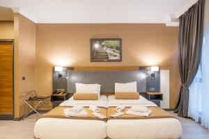 2 Betten in einem Hotelzimmer mit Handtüchern darauf in der Unterkunft ORANGE HOTEL & Spa in Istanbul