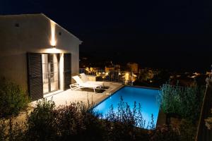 uma villa com piscina à noite em Villa HUGO, Neuve, 8 pers, pisc chauffée, em Brando