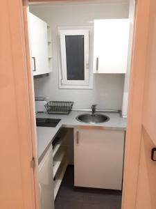 a small kitchen with a sink and a mirror at NEW! Apartment in Sarria near Metro in Barcelona