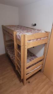 ein Etagenbett aus Holz in einem Zimmer mit in der Unterkunft Orelle Val Thorens Appartement 2 pieces 5 personnes aux portes du Parc de la Vanoise in Orelle