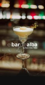 una bebida en un vaso de martini sobre una mesa en Room Mate Alba en Madrid