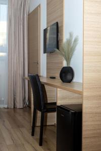 Habitación con escritorio, TV y silla. en Hotel Muli en Reikiavik