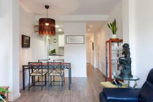 una sala da pranzo e una cucina con tavolo e sedie di Cozy Apartment near Fira Gran Via with AC a Hospitalet de Llobregat