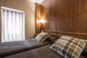 Riu Nere Mountain Apartments في فييا: غرفة نوم عليها سرير ووسادتين