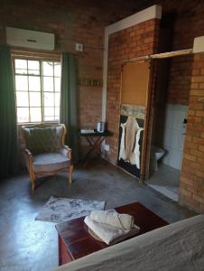 ein Wohnzimmer mit einem Spiegel, einem Sofa und einem Stuhl in der Unterkunft Bush and Gables House in Marloth Park