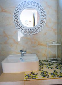 uma casa de banho com um lavatório branco e um espelho. em Gem's Paradise Resort em Cebu