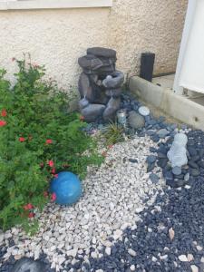 a garden with rocks and a blue ball and a plant at LA DOLCE VITA in Bretenière