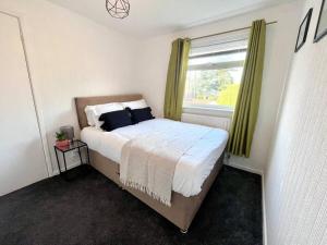 a bedroom with a large bed with a window at Three bedroom house, close to airport, A1, NCL in Kenton