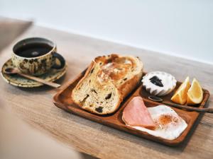 高野山にある高野山 ゲストハウス コクウのテーブルにパンとコーヒーを置いて