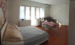 sypialnia z łóżkiem i stołem z krzesłami w obiekcie La Siesta Bogács Apartman w Bogácsu